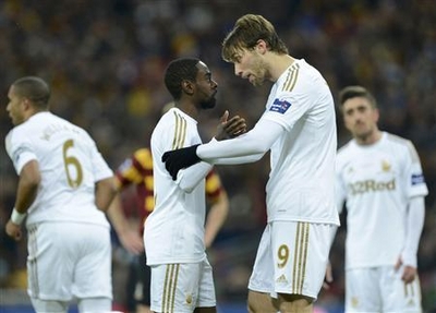 Swansea City's Nathan Dyer is consoled by Miguel Michu after he wasn't allowed to take a penalty during their English League Cup final soccer match against Bradford City at Wembley Stadium in London