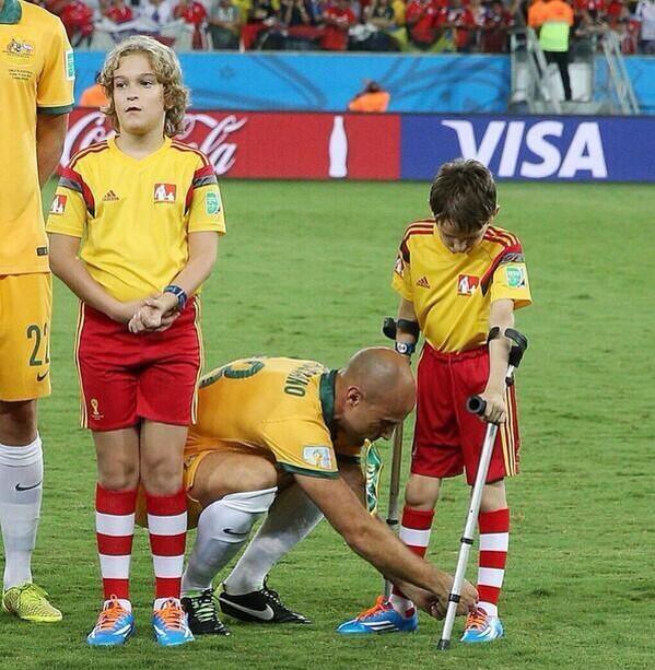 Bresciano jugador de Australia ayudó a un niño con muletas a atarse las botas.