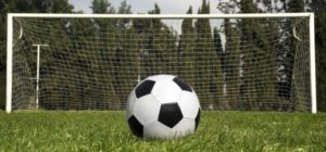 A soccer ball in front of a goal post
