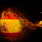 Composite image of fire surrounding spain ball against black